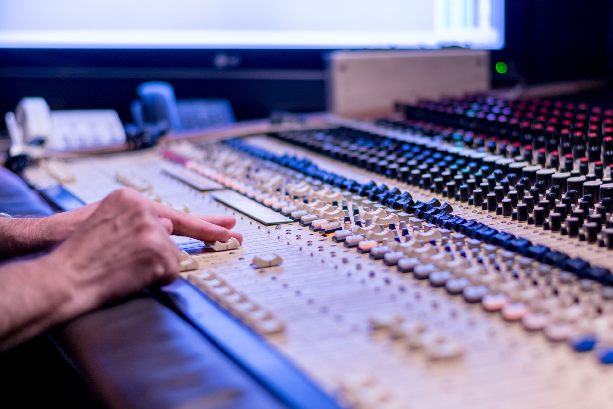 A hand pushing buttons on a soundboard